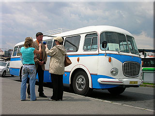 editel spolenosti p. Miroslav Hucl promlouv k poslucham rozhlasovch vln, v pozad historick autobus KODA 706 RTO